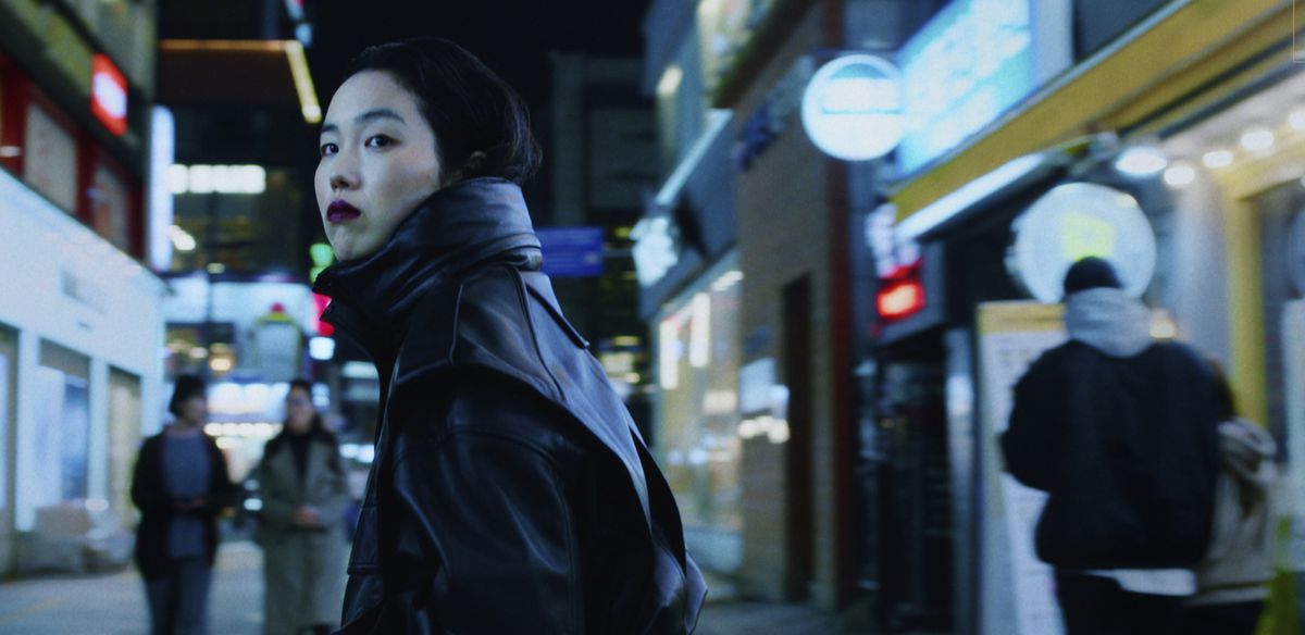 一位年轻女子晚上站在首尔。